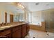 Bathroom with double vanity, soaking tub, tiled shower, and decorative details at 18017 W Desert Ln, Surprise, AZ 85388