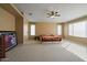 Large bedroom with carpeted floors, ceiling fan, and generous natural light from multiple windows at 18017 W Desert Ln, Surprise, AZ 85388