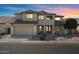 Two-story home with desert landscaping, a three-car garage, and a well-manicured front yard at 18017 W Desert Ln, Surprise, AZ 85388