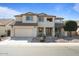 Two-story home featuring stucco exterior, desert landscaping, attached two car garage, and a covered front entryway at 18017 W Desert Ln, Surprise, AZ 85388