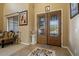 The home's entryway features decorative tile flooring, a sitting area, and a front door with glass accents at 18017 W Desert Ln, Surprise, AZ 85388