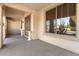 Covered front porch with decorative columns, a large window, and a glimpse of desert plants at 18017 W Desert Ln, Surprise, AZ 85388