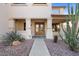 Inviting front porch with decorative pillars, double doors, and desert landscaping, creating a warm entry at 18017 W Desert Ln, Surprise, AZ 85388