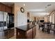 Open kitchen featuring a center island, stainless steel refrigerator, and seamless flow to the dining area at 18017 W Desert Ln, Surprise, AZ 85388
