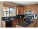 Lovely kitchen with wood cabinets, black countertops, and modern appliances at 18017 W Desert Ln, Surprise, AZ 85388