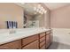 Bathroom featuring a double vanity with cabinets, large mirror, and soaking tub at 21134 W Sunrise Ln, Buckeye, AZ 85396