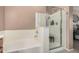 Bathroom featuring a soaking tub and glass enclosed shower for convenience and luxury at 21134 W Sunrise Ln, Buckeye, AZ 85396