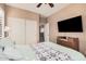 Comfortable bedroom features a ceiling fan, TV, and closet with sliding doors at 21134 W Sunrise Ln, Buckeye, AZ 85396