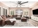 Spacious living room with a large sectional sofa, neutral tones, and modern ceiling fan at 21134 W Sunrise Ln, Buckeye, AZ 85396