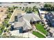 View of a red brick home with a private pool, putting green, driveway, and lush green lawns in a gated community at 2222 N Val Vista Dr # 2, Mesa, AZ 85213