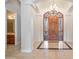 Grand foyer showcasing a decorative chandelier, elegant tile flooring, and a custom wooden door at 2222 N Val Vista Dr # 2, Mesa, AZ 85213