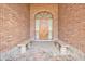 Inviting arched entryway featuring a detailed wooden door, brick walls, and two comfortable benches at 2222 N Val Vista Dr # 2, Mesa, AZ 85213