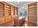 Home office featuring custom built-in shelves, a large desk, and natural light from the window at 2222 N Val Vista Dr # 2, Mesa, AZ 85213