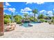Backyard pool and patio area featuring a rock waterfall, tropical landscaping, and ample seating at 2222 N Val Vista Dr # 2, Mesa, AZ 85213