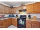 Kitchen offers oak cabinets, black appliances, and tile flooring at 25746 W Hess Ave, Buckeye, AZ 85326