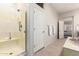 Bright bathroom with a glass shower, soaking tub, tile floors and an open doorway to the main bedroom at 42017 N Crooked Stick Rd, Anthem, AZ 85086