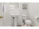 Cozy powder room with pedestal sink, toilet, and decorative rose art at 42017 N Crooked Stick Rd, Anthem, AZ 85086
