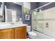 Bathroom featuring a wood vanity, shower with glass door, and blue accent wall with decorative mirror at 42017 N Crooked Stick Rd, Anthem, AZ 85086