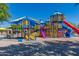 A colorful community playground area featuring slides, towers, and climbing structures on a sunny day at 42017 N Crooked Stick Rd, Anthem, AZ 85086