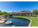 Community train station with a pond in the foreground, reflecting the sky and the structure on a sunny day at 42017 N Crooked Stick Rd, Anthem, AZ 85086