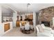 Open-concept dining area features a glass table, chandelier, and adjacent kitchen with modern wood cabinets at 42017 N Crooked Stick Rd, Anthem, AZ 85086