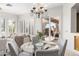 Bright dining area features a modern chandelier and sliding glass doors to a covered patio with outdoor grill at 42017 N Crooked Stick Rd, Anthem, AZ 85086