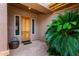 Inviting covered porch with wood front door and potted plant accent at 42017 N Crooked Stick Rd, Anthem, AZ 85086