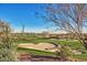 Scenic golf course view featuring a sand trap, lush greenery, and distant mountain views under a clear blue sky at 42017 N Crooked Stick Rd, Anthem, AZ 85086