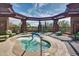 Inviting hot tub area with shaded pergola and comfortable lounge seating, perfect for relaxation at 42017 N Crooked Stick Rd, Anthem, AZ 85086