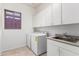 Functional laundry room with ample storage, a sink, and modern appliances for convenience at 42017 N Crooked Stick Rd, Anthem, AZ 85086