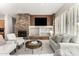 Inviting living room featuring a stacked stone fireplace, custom built-ins, and bright window shutters at 42017 N Crooked Stick Rd, Anthem, AZ 85086