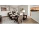 Open-concept living area with hardwood floors, stylish furniture and a view into the dining room and kitchen at 42017 N Crooked Stick Rd, Anthem, AZ 85086