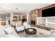 Spacious living room with stone fireplace, media center, and seamless flow to the dining and kitchen areas at 42017 N Crooked Stick Rd, Anthem, AZ 85086