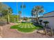 Expansive backyard featuring lush green grass, mature palm trees, and a pool area, perfect for outdoor living at 4340 E Turquoise Ave, Phoenix, AZ 85028