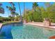 Luxury pool with rock features surrounded by lush landscaping and pavers at 4340 E Turquoise Ave, Phoenix, AZ 85028