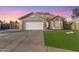 House exterior featuring a two-car garage and well-manicured lawn at 4446 W Townley Ave, Glendale, AZ 85302