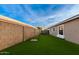 Artificial turf side yard with block wall and small tree at 4446 W Townley Ave, Glendale, AZ 85302