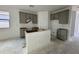 An unfinished kitchen features gray cabinetry and a central island, ready for customization at 47733 W Moeller Rd, Maricopa, AZ 85139