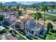 Aerial view of condo community with manicured lawns, towering palms, and a golf course backdrop at 7356 N Via Camello Del Norte -- # 208, Scottsdale, AZ 85258