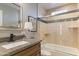 Elegant bathroom featuring granite countertop, undermount sink, and tub with glass enclosure at 7844 E Coolidge St, Scottsdale, AZ 85251