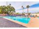 Large community pool with an abundance of lounge chairs and palm trees at 7844 E Coolidge St, Scottsdale, AZ 85251
