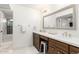 Elegant bathroom with double vanities, a large mirror, and a glass-enclosed shower at 8708 E San Lucas Dr, Scottsdale, AZ 85258