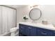 Modern bathroom featuring a blue vanity cabinet, white countertop, round mirror, and shower with a white curtain at 8708 E San Lucas Dr, Scottsdale, AZ 85258