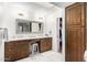 Bathroom featuring double vanities, decorative mirror, and ample storage at 8708 E San Lucas Dr, Scottsdale, AZ 85258