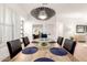 Dining room featuring an elongated wooden table, modern chandelier, and stylish place settings at 8708 E San Lucas Dr, Scottsdale, AZ 85258