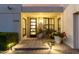 Inviting front entrance featuring a modern glass door, plants, and warm exterior lighting at 8708 E San Lucas Dr, Scottsdale, AZ 85258