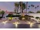 Twilight front yard featuring desert landscaping, landscape lighting, and mature palm trees at 8708 E San Lucas Dr, Scottsdale, AZ 85258