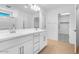 Bright bathroom featuring double sinks, a large mirror, white cabinets and drawers, and a shower at 9036 S 196Th Dr, Goodyear, AZ 85338
