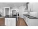 Modern kitchen with white cabinets, gray countertops, stainless steel appliances, and wood floors at 9036 S 196Th Dr, Goodyear, AZ 85338