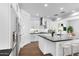 Modern kitchen featuring a stainless steel refrigerator and range hood, white cabinetry, and a black countertop island at 9036 S 196Th Dr, Goodyear, AZ 85338